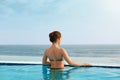Luxury Resort. Woman Relaxing In Infinity Swimming Pool Water. Beautiful Happy Healthy Female Model Enjoying Summer Travel Vacatio Royalty Free Stock Photo