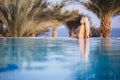 Luxury Resort. Woman Relaxing In Infinity Swimming Pool Water. Beautiful Happy Healthy Female Model Enjoying Summer Travel Vacatio Royalty Free Stock Photo