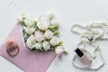 Luxury romantic background: white flowers, pearls necklace, perfume, greeting card on white.accessories and flowers Royalty Free Stock Photo