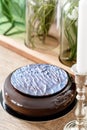 Luxury round chocolate dessert, with a blue disk on Black glaze. Mousse birthday cake with decor. on a wooden table
