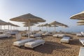 Luxury sand beach with beach chairs and white straw umbrellas in tropical resort in Red Sea coast in Egypt, Africa Royalty Free Stock Photo