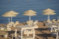 Luxury sand beach with beach chairs and white straw umbrellas in tropical resort in Red Sea coast in Egypt, Africa Royalty Free Stock Photo