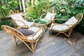 Luxury set group of four brown bending rattan chair and table with white cotton cushion on wooden floor for relax comfortable