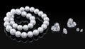 Luxury set white pearl necklace and diamonds on a black background with glossy reflection Royalty Free Stock Photo