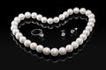 Luxury set white pearl necklace and jewelry with diamonds in ring and earrings on a black background Royalty Free Stock Photo