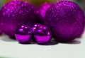 Luxury, shiny, large and small purple Christmas balls close-up on a white table at home. Bright Christmas decorations. Selective f Royalty Free Stock Photo