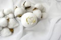 Luxury spa composition. White bath bomb with cotton flowers on silk fabric background.