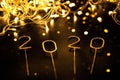 Luxury sparkling numbers 2020 with golden lights on black background.