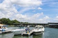 Luxury speedboats fueling up at gas pump at marina on lake with docks and boats behind under beautiful blue cloudy sky Royalty Free Stock Photo