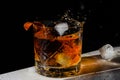 Luxury still life of whiskey glass, on the rocks, with ice cube falling into Glass of Whisky, Freeze Motion.Copy space. Splash Royalty Free Stock Photo