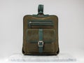 Luxury suet backbag. Luxury green leather and suet backpack on white background, on marble floor.