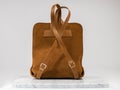 Luxury suet backbag. Luxury orange leather and suet backpack on white background, on marble floor.