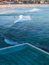 A luxury Swimming pool next to blue Ocean on Sunny day Royalty Free Stock Photo