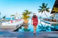 Luxury swimming pool in tropical resort, relaxing holidays in Seychelles islands. La Digue, Young man during sunset by