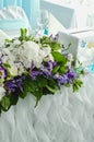 Luxury table beautiful, rich decoration with lush leaves, white hydrangea, delicate cream roses, purple eustoma, blue Royalty Free Stock Photo