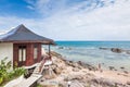 Luxury thatched roof over sea bungalow resort in a vacation resort in the clear blue lagoon with a view on the tropical island.