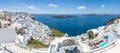 Luxury travel destination in Santioni island, Greece. White houses and caldera sea view with loungers under blue sky, romance Royalty Free Stock Photo