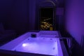 Luxury travel Santorini vacation hotel jacuzzi in colored lights with night view of the city. Royalty Free Stock Photo