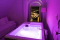 Luxury travel Santorini vacation hotel jacuzzi in colored lights with night view of the city. Royalty Free Stock Photo