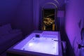 Luxury travel Santorini vacation hotel jacuzzi in colored lights with night view of the city. Royalty Free Stock Photo