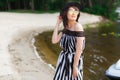 Luxury travel woman in black and white beachwear walking taking a stroll on sand summer beach. Girl tourist on summer Royalty Free Stock Photo