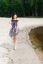 Luxury travel woman in black and white beachwear walking taking a stroll on sand summer beach. Girl tourist on summer Royalty Free Stock Photo