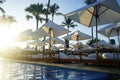 Luxury umbrellas and chairs around outdoor swimming pool with beach view. Luxurious vacation and holiday concept Royalty Free Stock Photo