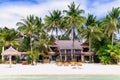 Luxury villa and palm trees around at beautiful white sandy beach