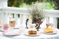 Luxury vintage coffee cup and tea, fruit cake,vintage milk jug, vintage flora on aged white table at balcony for breakfast Royalty Free Stock Photo