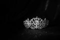 Luxury vintage crown on dark red satin, silk background. Black and white Royalty Free Stock Photo