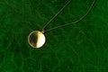 Luxury vintage golden round pendant jewelry with chain necklace accessory for women on green velvet background Royalty Free Stock Photo