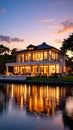 Luxury waterfront mansion illuminated at twilight with reflection on calm water Royalty Free Stock Photo