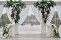 Luxury wedding arch decorated with palm leaves, orchid flowers and floral peacocks outdoors, copy space. Wedding ceremony.