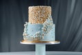 Luxury wedding cake on table, blue and gold frosting, pearl icing Royalty Free Stock Photo