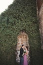 Luxury wedding couple hugging and kissing on the background gorgeous plants, cave near ancient castle Royalty Free Stock Photo
