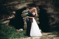 Luxury wedding couple hugging and kissing on the background gorgeous plants and cave near ancient castle Royalty Free Stock Photo