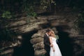 Luxury wedding couple hugging and kissing on the background gorgeous plants and cave near ancient castle Royalty Free Stock Photo