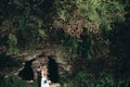 Luxury wedding couple hugging and kissing on the background gorgeous plants and cave near ancient castle Royalty Free Stock Photo