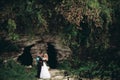 Luxury wedding couple hugging and kissing on the background gorgeous plants and cave near ancient castle Royalty Free Stock Photo