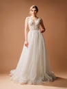 Luxury wedding dress. Fashionable bridal gown with tender french lace and beads, tulle skirt, front slit. Contemporary design.
