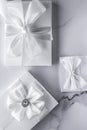 Luxury wedding gifts with silk bow and ribbons on marble background Royalty Free Stock Photo