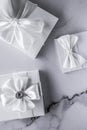 Luxury wedding gifts with silk bow and ribbons on marble background Royalty Free Stock Photo