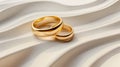 Luxury wedding rings on a smooth satin background. Elegant gold wedding bands entwined on silky fabric. Intertwined golden rings