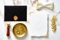 Luxury wedding stationery set. Flat lay blank paper wedding invitation card template, black envelope, gold rings, wax seal stamp, Royalty Free Stock Photo