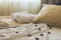 Luxury wellness and spa hotel room arranged for romantic weekend. Honeymoon suite bedroom decorated with rose petals on bed sheets Royalty Free Stock Photo