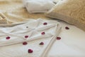 Luxury wellness and spa hotel room arranged for romantic weekend. Honeymoon suite bedroom decorated with rose petals on bed sheets