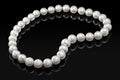 Luxury white pearl necklace on a black background with glossy reflection Royalty Free Stock Photo