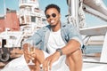 Luxury, wine glass and man on a yacht for holiday vacation on the ocean or sea with sunglasses. Gen z entrepreneur