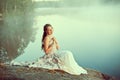 Luxury woman in a forest in a long vintage dress near the lake. Royalty Free Stock Photo