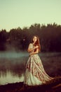 Luxury woman in a forest in a long vintage dress near the lake. Royalty Free Stock Photo